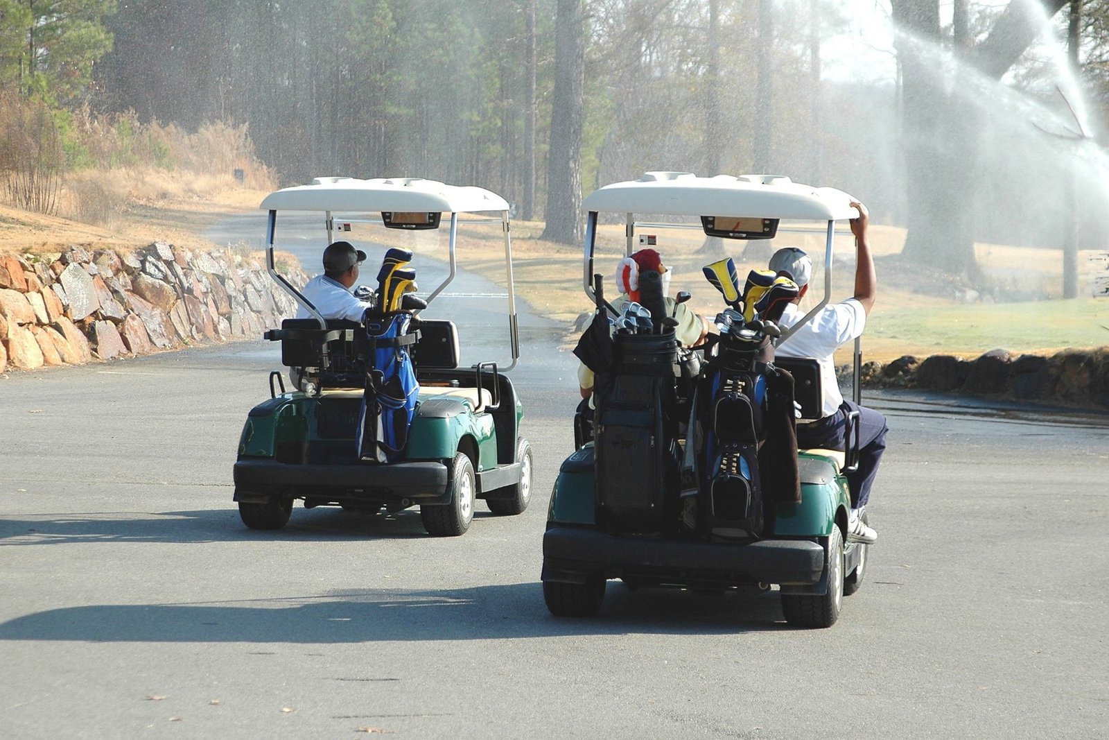 Golf carts driving along a golf course